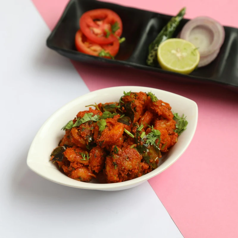 Crispy fried chicken 65 garnished with curry leaves and green chili